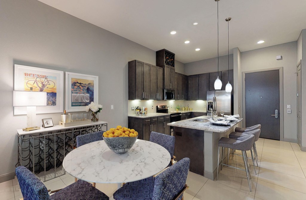 Luxury apartments with spacious kitchens with granite countertops, large granite slab island, built-in wine rack, and stainless appliances at Le Palais Apartments in Houston.