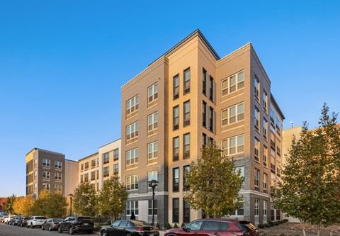 A multi-story building with a parking lot in front.