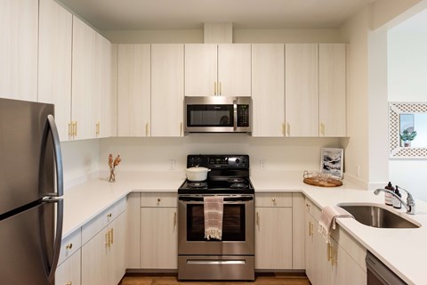 A kitchen with white cabinets and a stainless steel refrigerator.