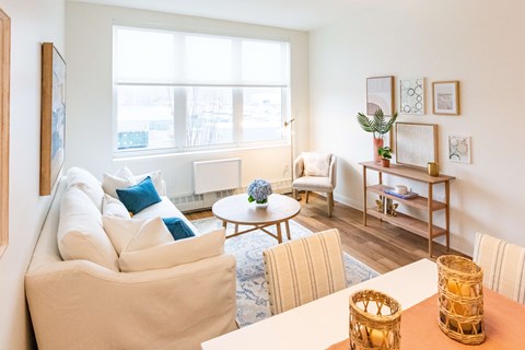 A living room with a white couch and a wooden coffee table.