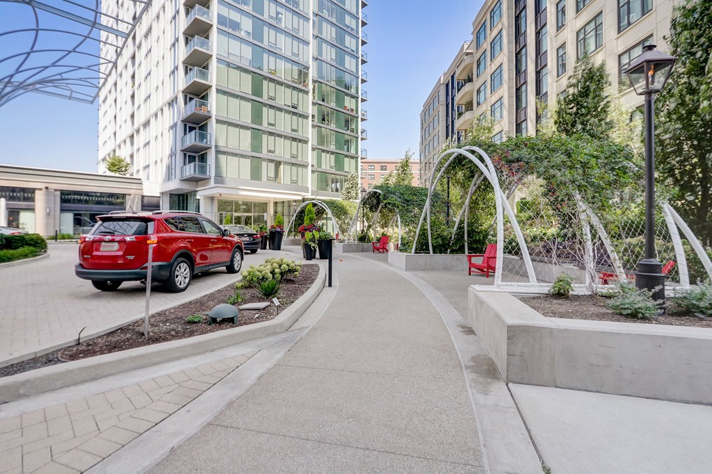 City street with a red car parked on the side of the street at The Apartments at Lincoln Common, 60614