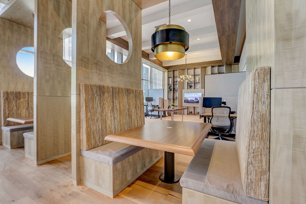 Table and benches in a room with a desk and chairs at The Apartments at Lincoln Common, Chicago, IL