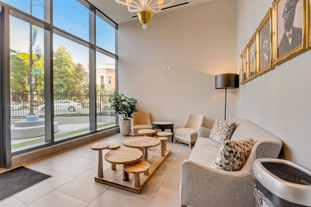 Living room with a couch and chairs and a large window at The Apartments at Lincoln Common, Chicago, 60614