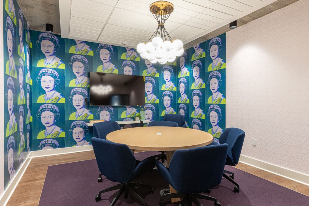 a conference room with a table and chairs and a wall mural of women