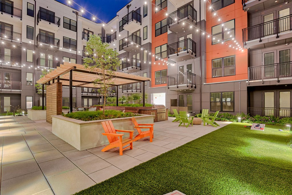 a courtyard with a picnic area in front of an apartment building