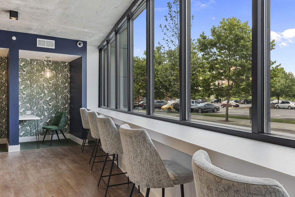 a seating area with chairs and a counter with large windows