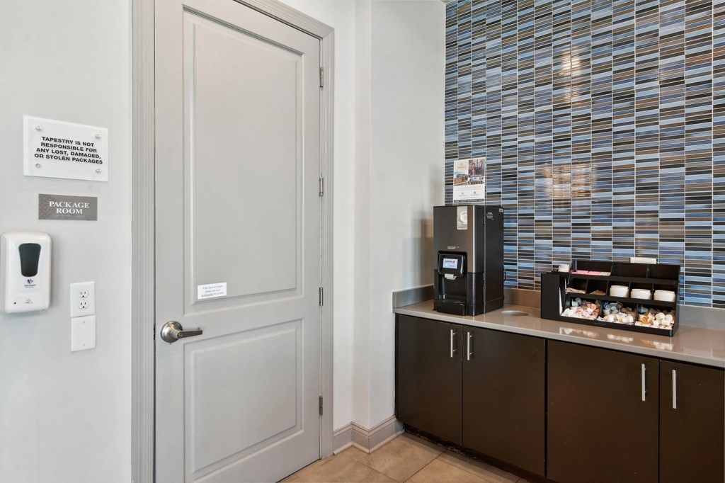 a room with a counter with a coffee machine and a door
