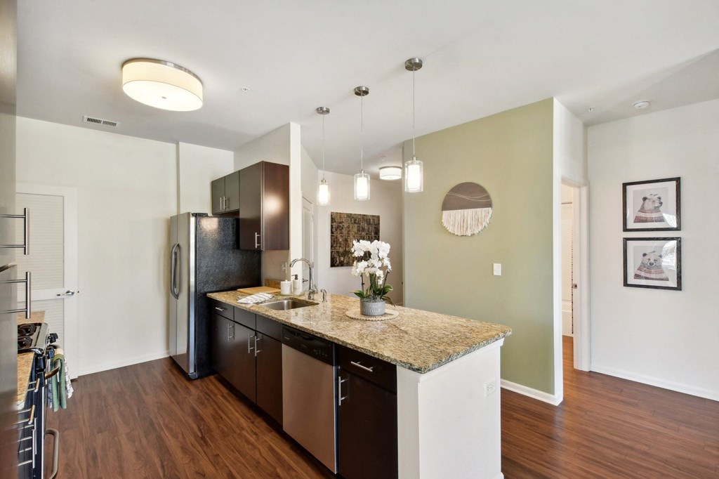 a kitchen with a granite counter top and a stainless steel refrigerator