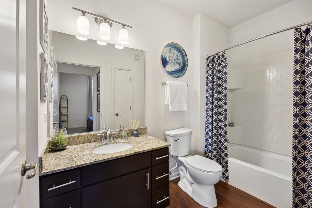 a bathroom with a toilet sink and shower and a mirror