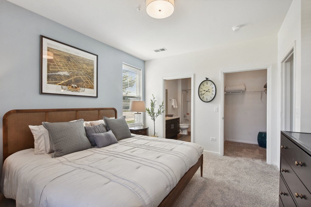 a bedroom with a large bed and a clock on the wall