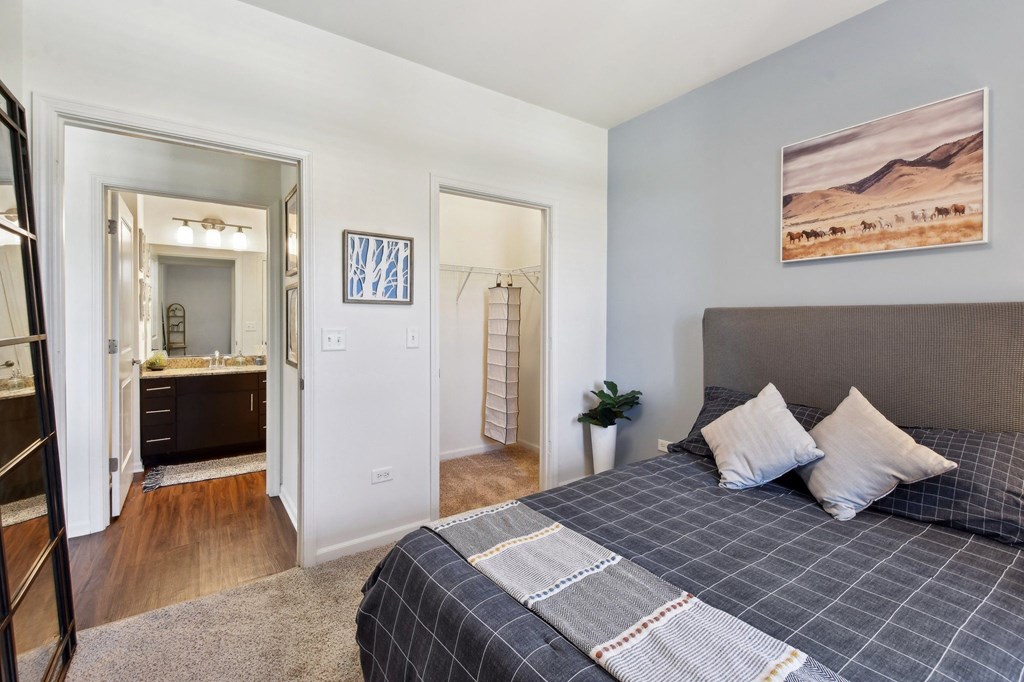 a bedroom with a bed and a bathroom with a mirror