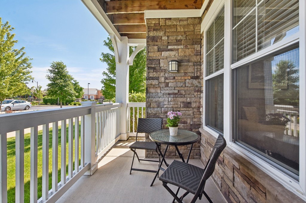 a patio with two chairs and a table on a porch