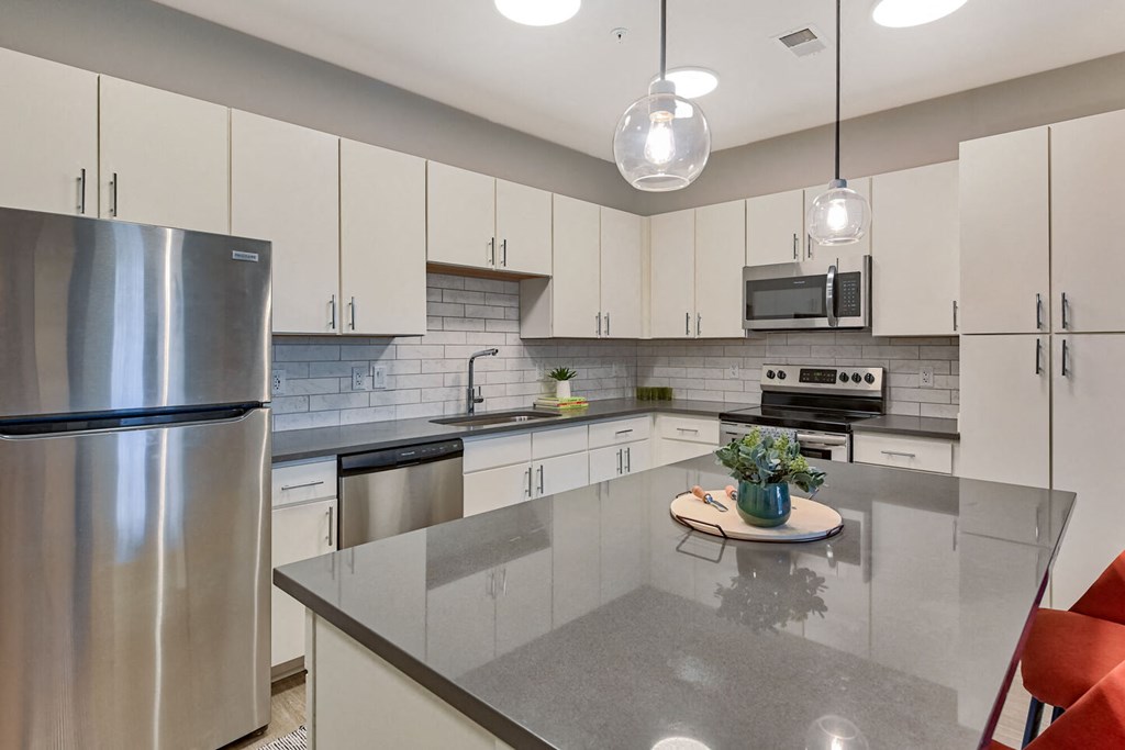a modern kitchen with stainless steel appliances and white cabinets