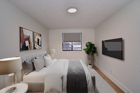 a bedroom with white walls and a bed with pillows