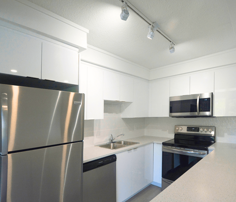 A modern kitchen with a stainless steel refrigerator and oven.