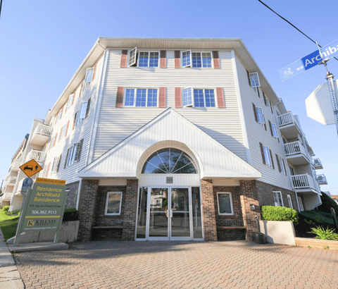 A large white building with a sign that says "Residence" in front of it.