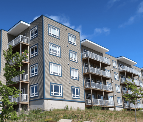A modern apartment building with balconies and windows.