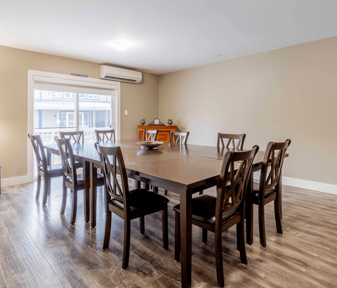 A dining room with a table and chairs.