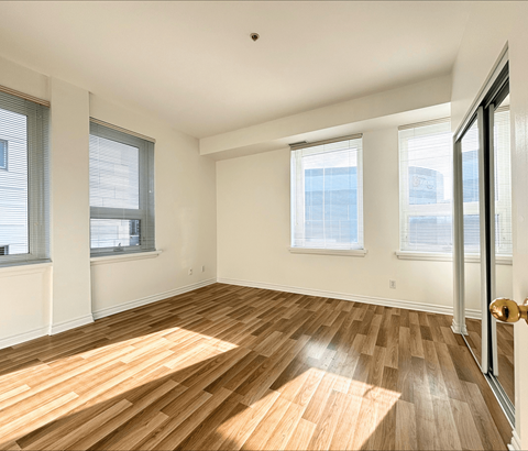 A room with wooden flooring and white walls.