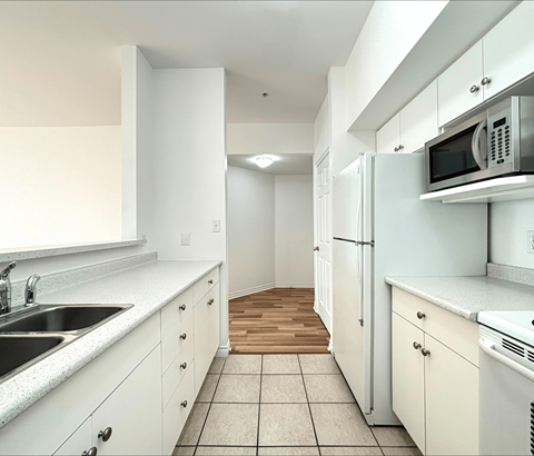 A kitchen with white cabinets and appliances.