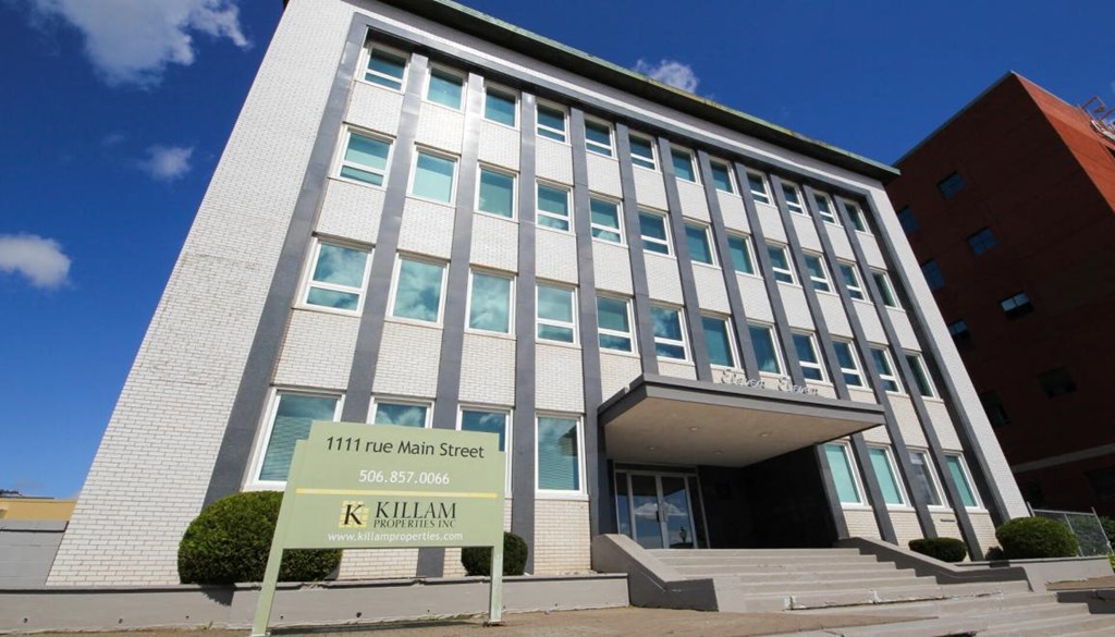 A building with a sign that says KILLAM in front of it.