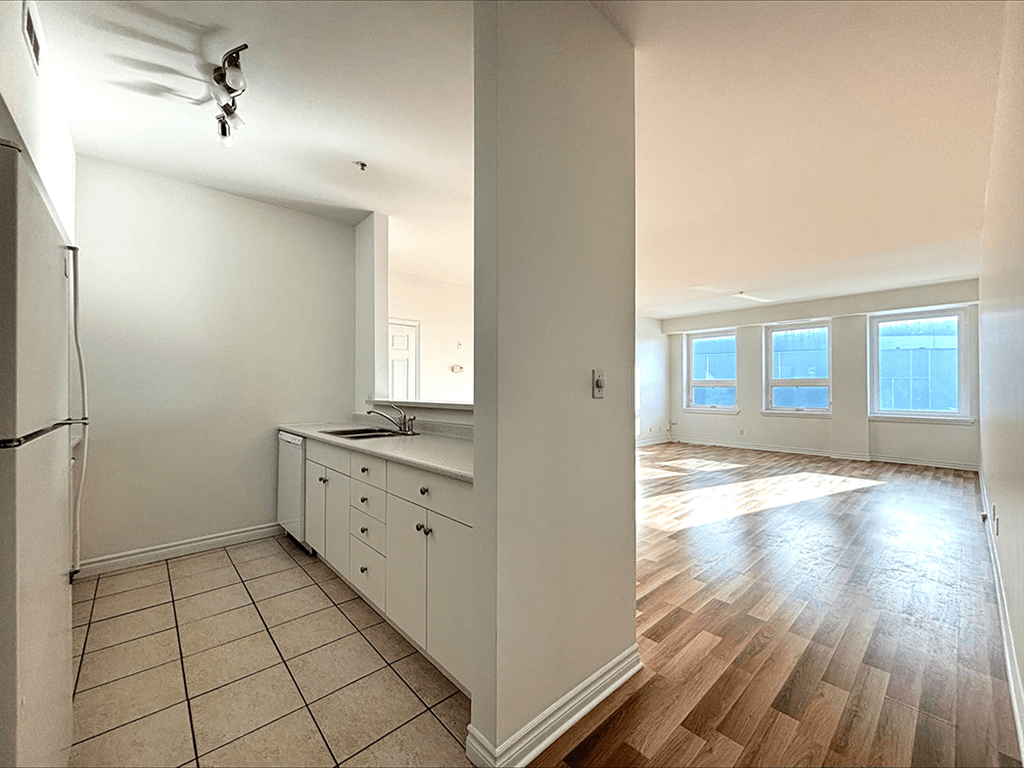A kitchen with white cabinets and a refrigerator.