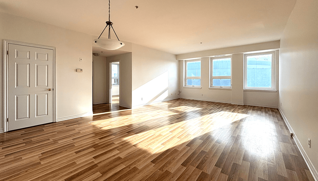 A room with wooden flooring and a white door.