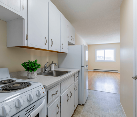 A kitchen with white cabinets and a stove top oven.
