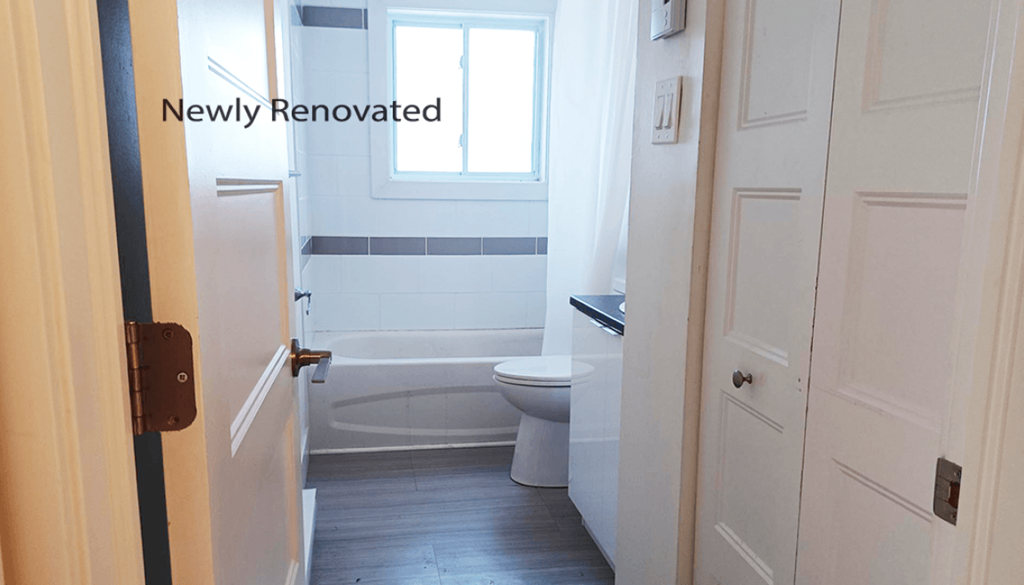A newly renovated bathroom with a toilet, tub, and sink.