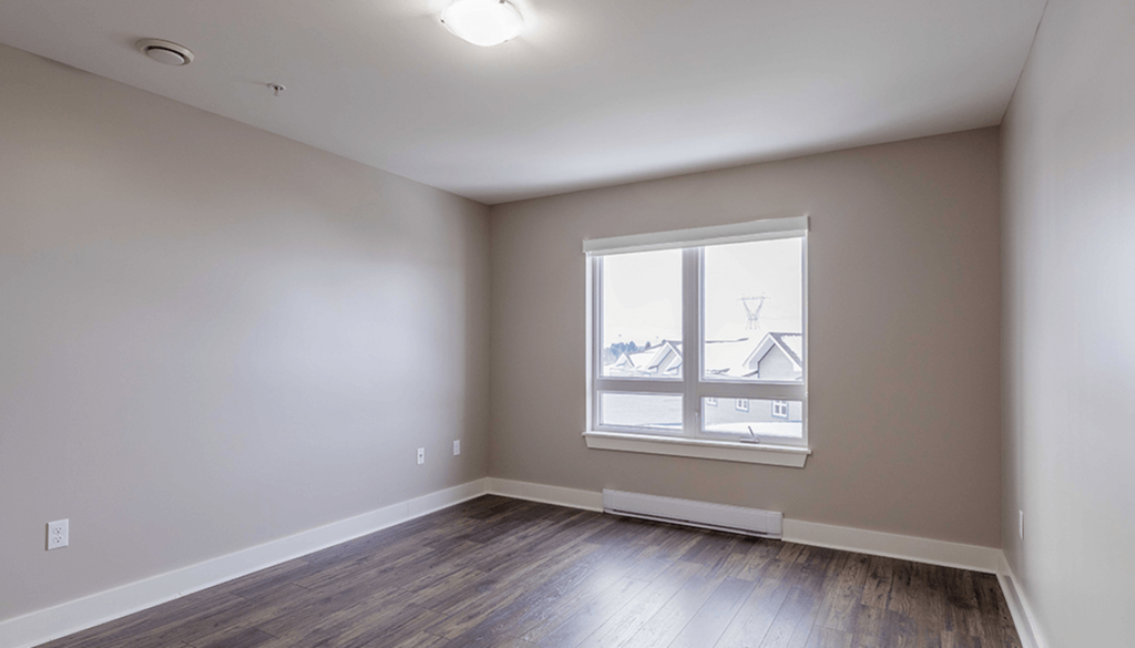 A room with a window showing a view of houses.