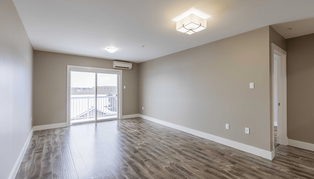A room with a sliding glass door leading to a balcony.