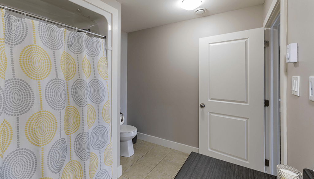 A bathroom with a shower curtain and a toilet.