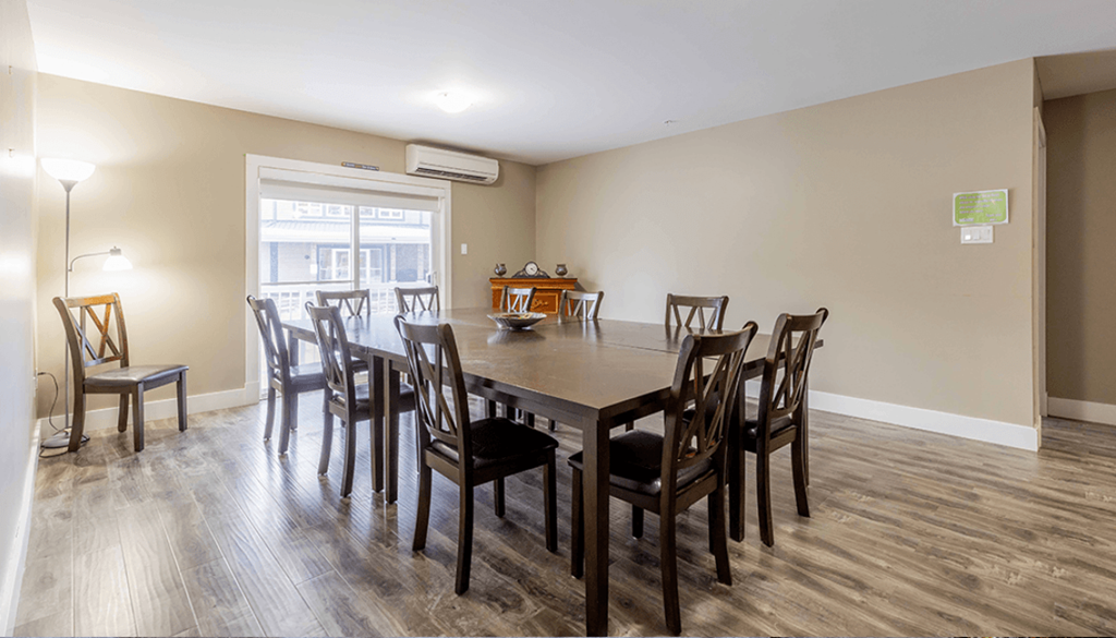 A dining room with a table and chairs.