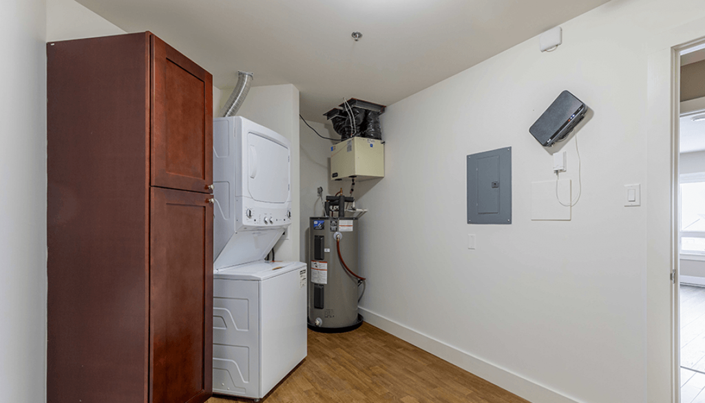 A room with a brown cabinet and a white fridge.