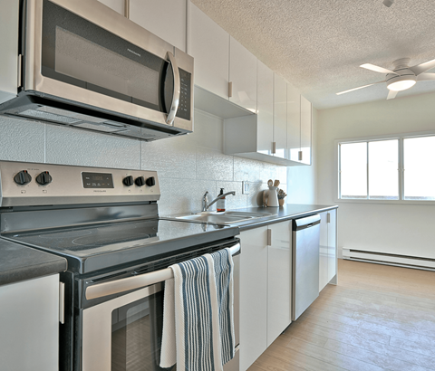 A modern kitchen with a stove top oven and microwave above it.