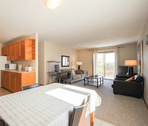 A bedroom with a bed, couch, and television.