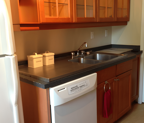A kitchen with a white dishwasher and a white refrigerator.