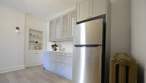 A stainless steel refrigerator sits next to a wall in a kitchen.