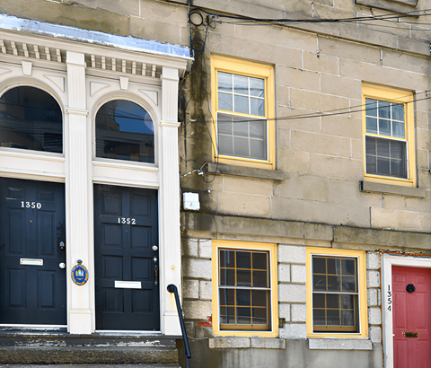 A building with a red door and a blue door with the number 1350 on it.