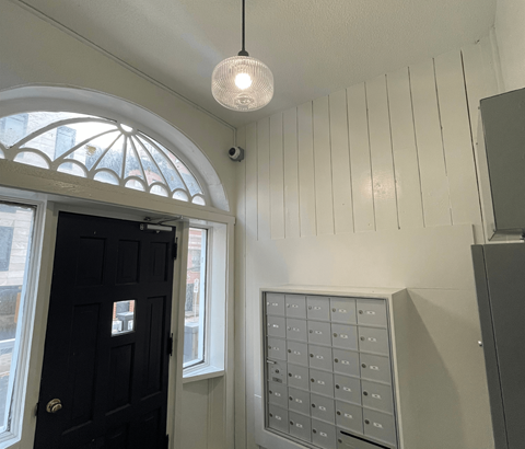 A black door is on the left of a wall with a mailbox.