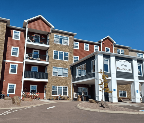 The image shows a multi-story residential building with a clear blue sky in the background.