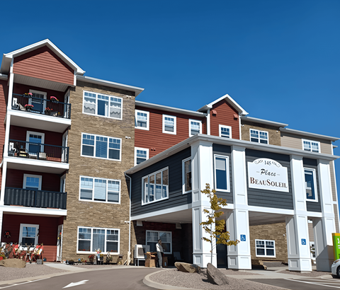 A large multi-story building with a sign that reads "Place Beausoleil" in front of it.