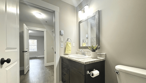 A bathroom with a sink, mirror, and bathtub.