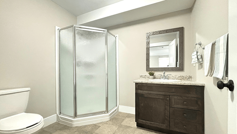 A bathroom with a toilet, sink, and shower.