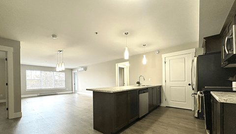 A kitchen with a sink, stove, and cabinets.