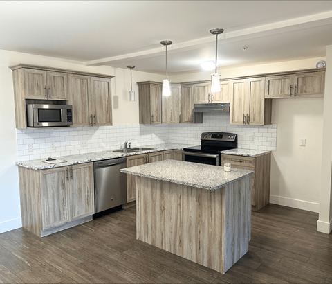 A kitchen with wooden cabinets and a granite countertop.