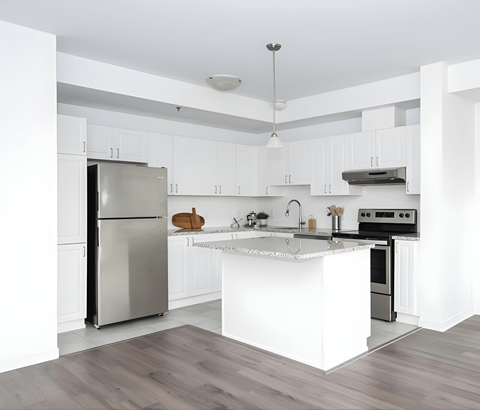 A modern kitchen with a stainless steel refrigerator and a white island.