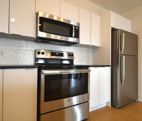 A modern kitchen with stainless steel appliances and white cabinets.