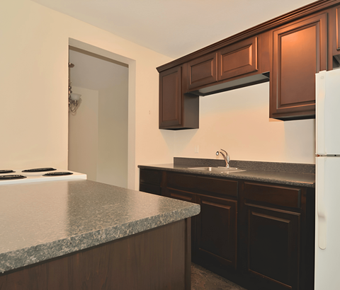 A kitchen with brown cabinets and a white refrigerator.