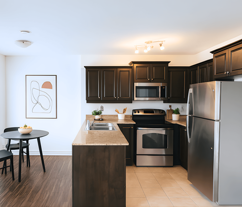 A modern kitchen with dark brown cabinets and stainless steel appliances.